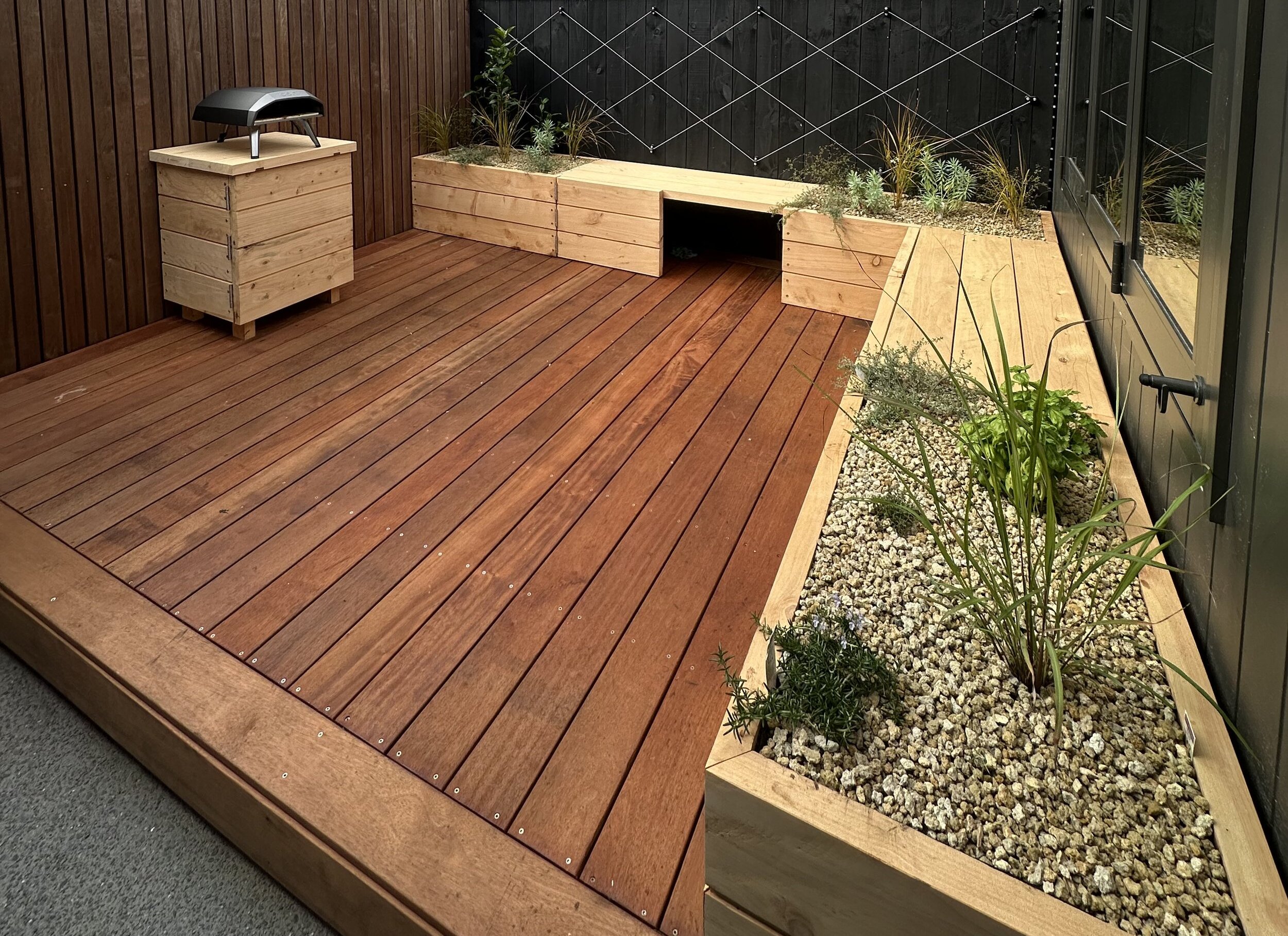 Spacious hardwood deck with stairs leading to a garden