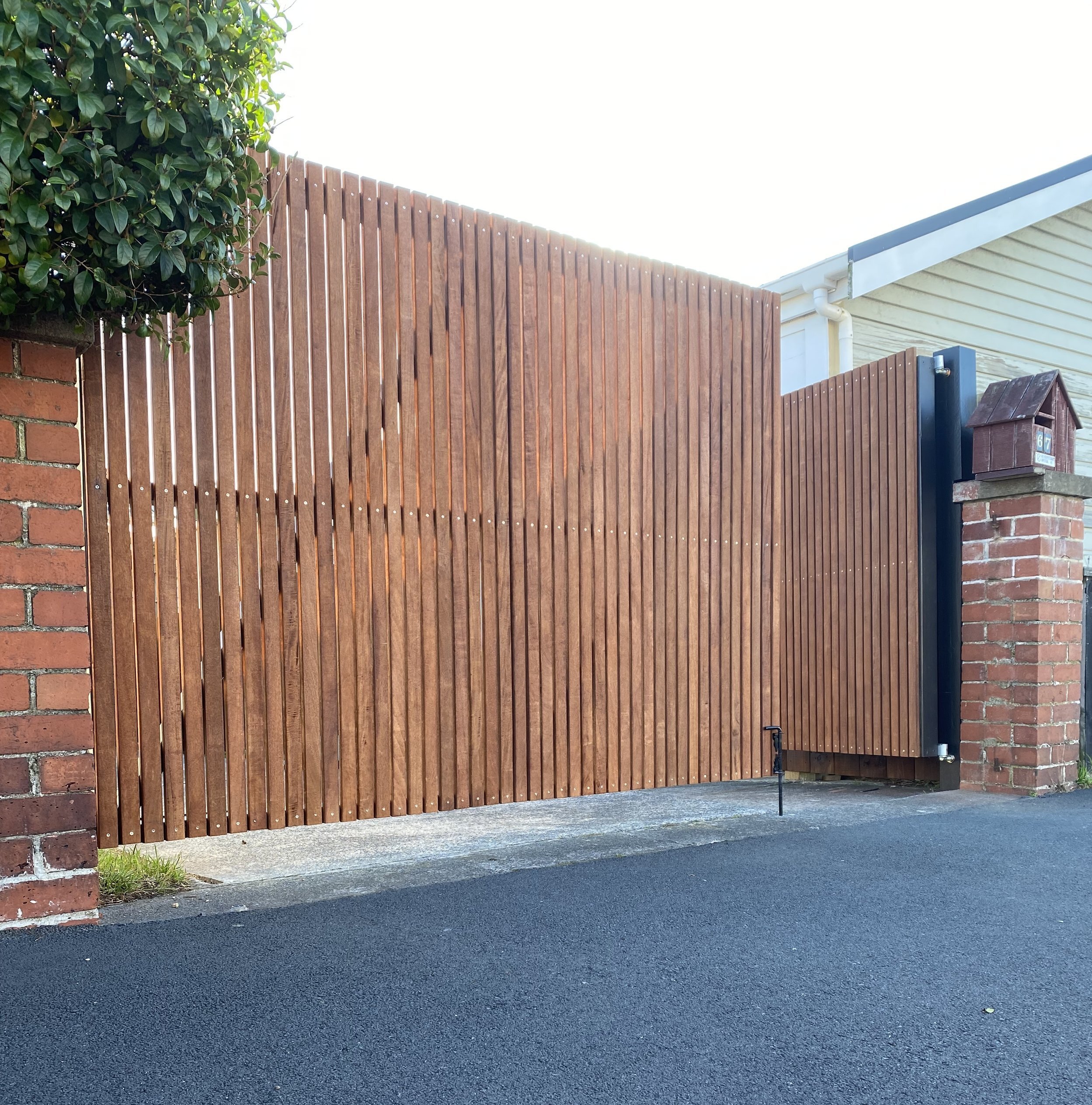 Modern horizontal slat wooden fence in a garden setting.