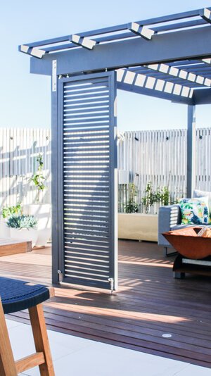 Outdoor dining area under the pergola, set for an evening meal.