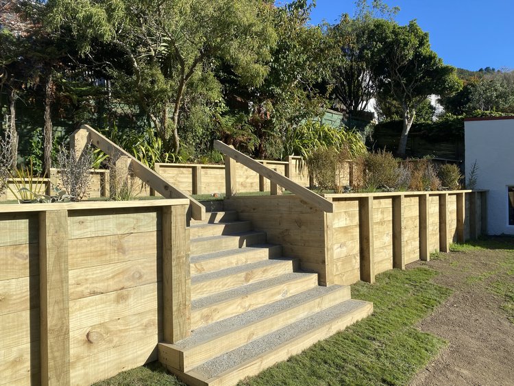 Wooden staircase next to a retaining wall